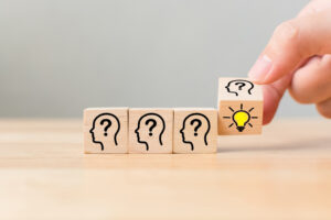 Concept creative idea and innovation. Hand flip over wooden cube block with head human symbol and light bulb icon